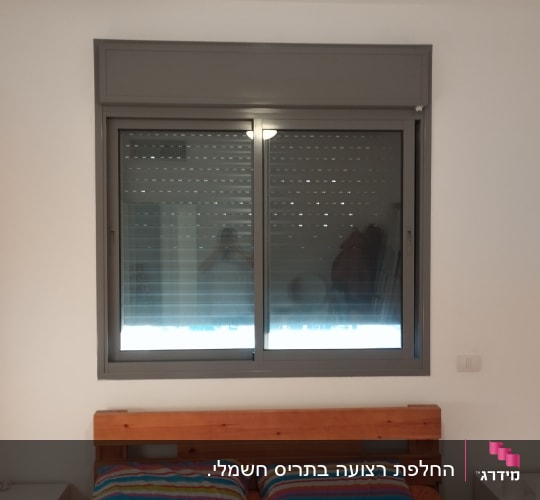 חלון עם תריסים סגורים בחדר שינה